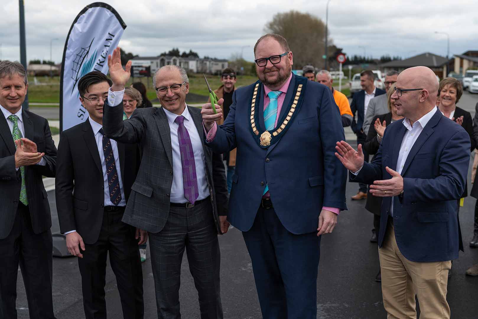 VIPs applauding the cutting of the ribbon at the opening of Silverstream Boulevard