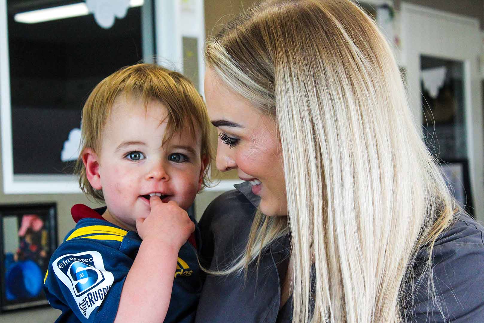 Teacher at Beststart Preschool holding young boy